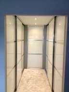 Wardrobes on both sides of a corridor between the bedroom and ensuite