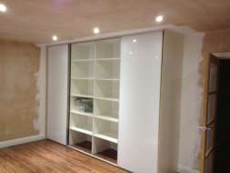 Plain white glass wardrobes doors with a minimal frame with middle doors open (from the right view)