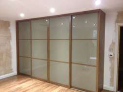 Light brown glass wardrobes doors with a walnut frame (from the right view)