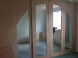 An arch spanning 4 doors with mirror inserts (exclusive to TaylorMade Wardrobes