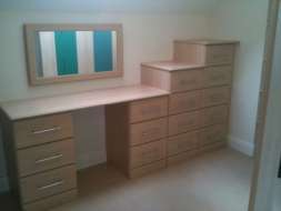 Dressing table with incrementing drawers and a wall mirror