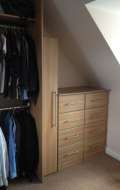 Narrow cupboard with a chest of drawers fitted into the eave of room