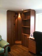 Cupboards and shelving fitted into the corner of a room