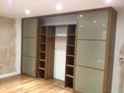 Light brown glass wardrobes doors with a walnut frame with doors open(from the right view)