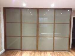 Light brown glass wardrobes doors with a walnut frame (straight on view)