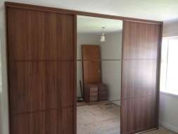 Dark walnut and mirror doors divided into 3 equal splits giving an oriental feel