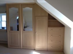 Sliding wardrobes with fitted hinged wardrobes going into the eave of the room