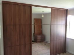 Dark walnut and mirror doors divided into 3 equal splits giving an oreiental fee